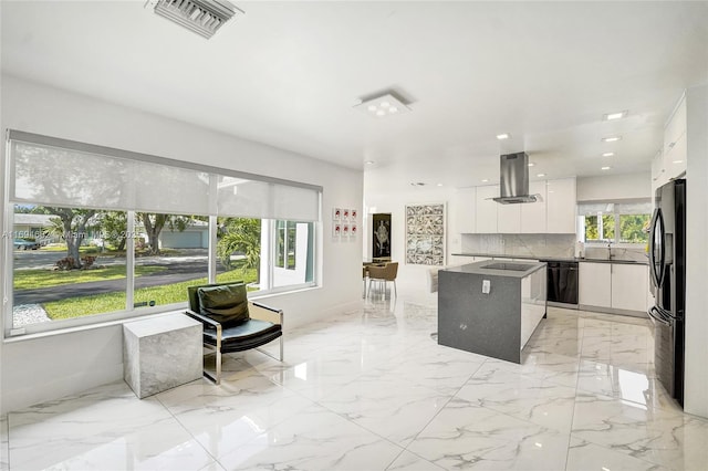 kitchen with a kitchen island, island range hood, tasteful backsplash, white cabinets, and black appliances