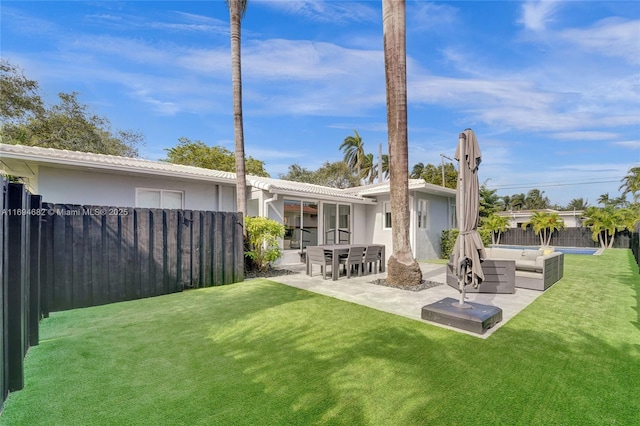 back of property with an outdoor hangout area, a patio area, and a lawn