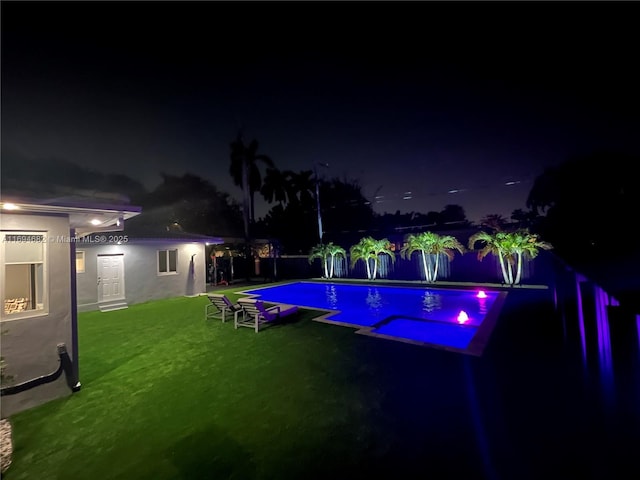 pool at night with a yard