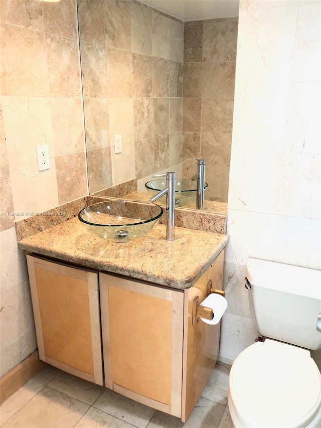 3901 S Ocean Dr Unit 2J, Hollywood, FL 33019 - half bathroom with tile walls, vanity, and toilet