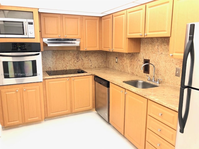 kitchen with backsplash, light stone counters, sink, and appliances with stainless steel finishes