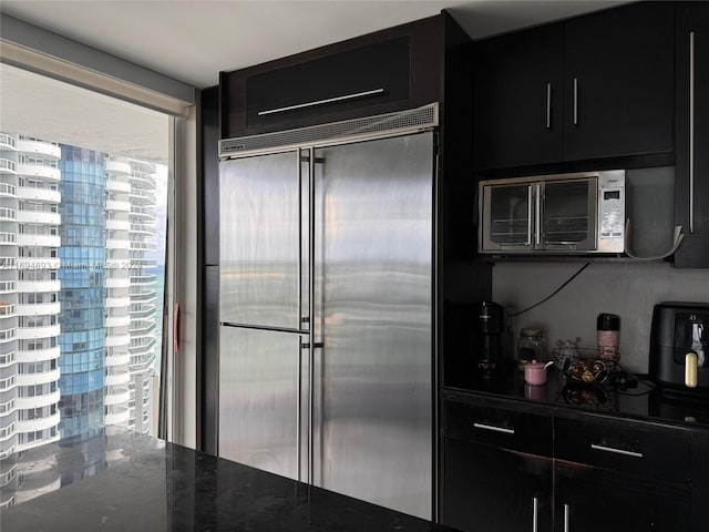 kitchen with stainless steel appliances and dark stone counters