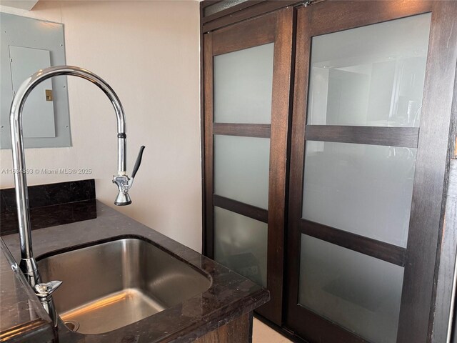 room details featuring dark stone countertops and sink