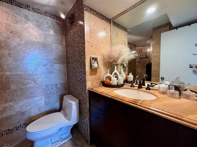 bathroom with vanity, toilet, and tile walls