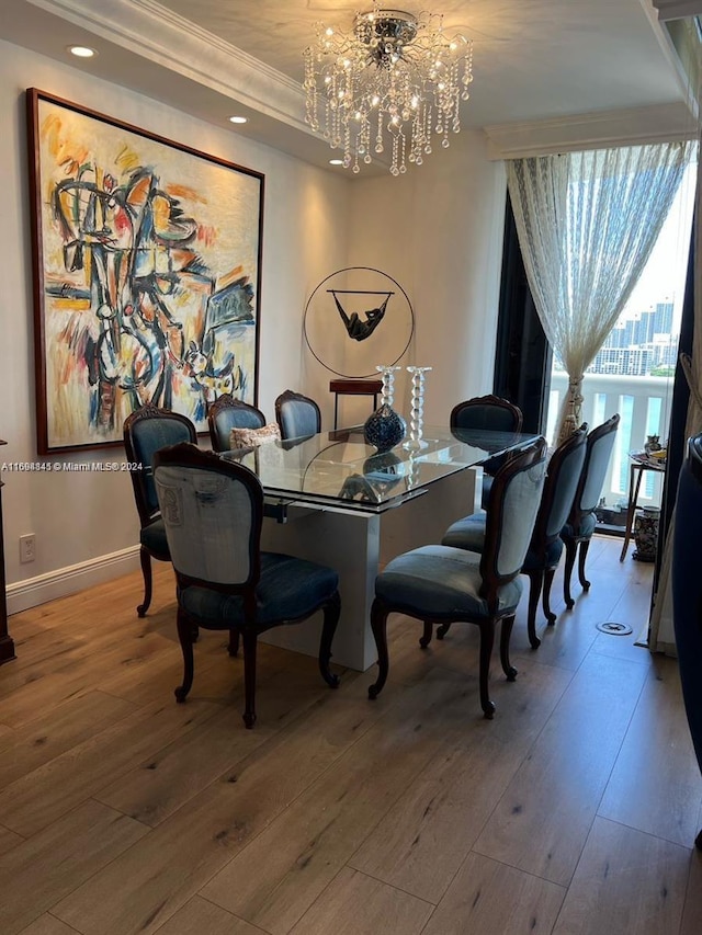 dining area with hardwood / wood-style floors, an inviting chandelier, and crown molding