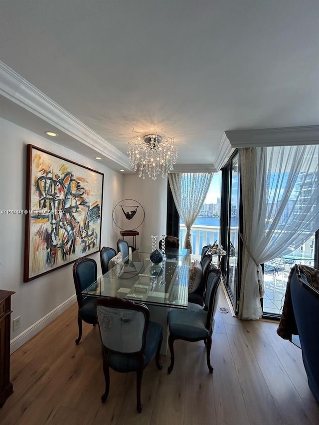 dining room with a chandelier, crown molding, and light hardwood / wood-style flooring