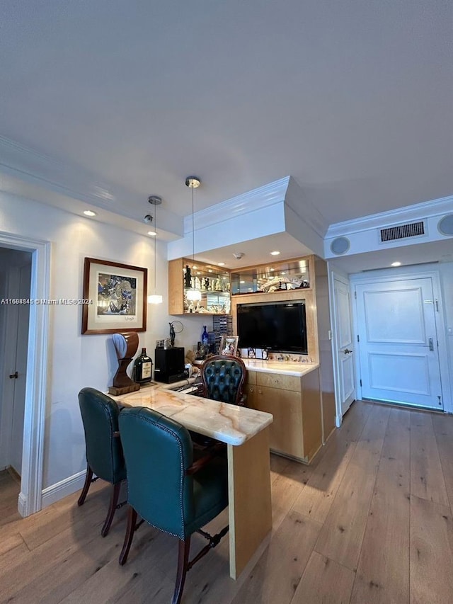 interior space with kitchen peninsula, a kitchen breakfast bar, decorative light fixtures, and light hardwood / wood-style floors