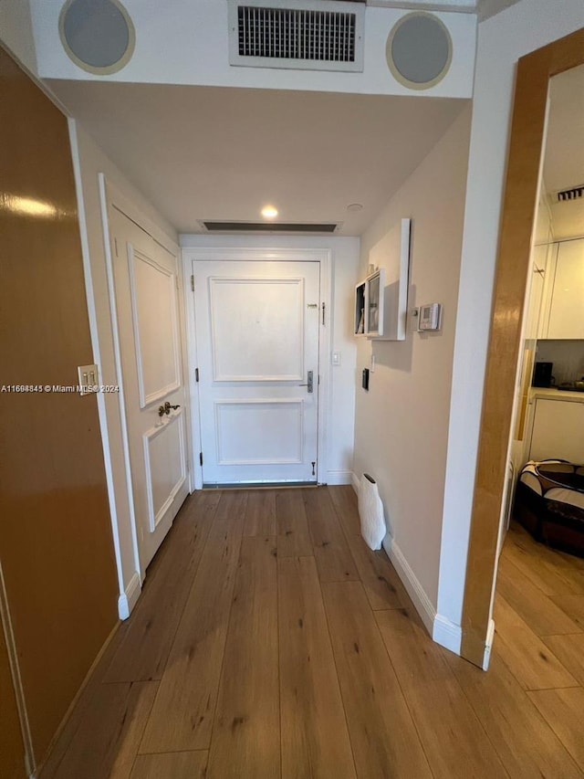 hallway with light hardwood / wood-style floors