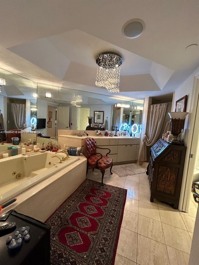 bathroom featuring tile patterned floors, a bathtub, vanity, a raised ceiling, and a notable chandelier