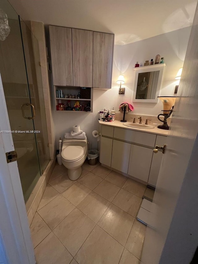 bathroom featuring an enclosed shower, vanity, toilet, and tile patterned flooring