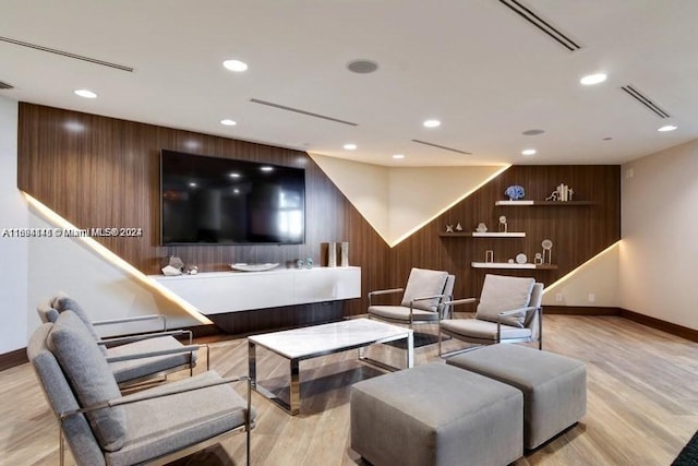 living room featuring light hardwood / wood-style floors and wooden walls