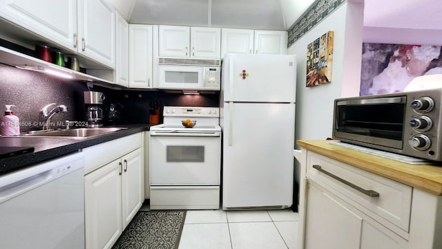 kitchen with white cabinetry, sink, white appliances, decorative backsplash, and light tile patterned flooring