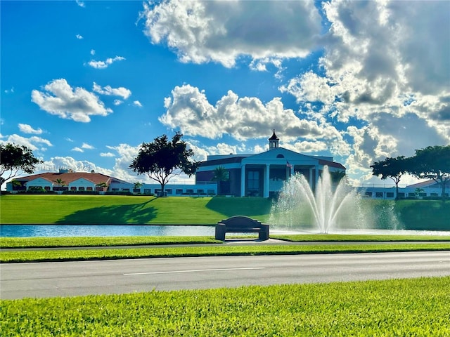 view of property's community with a yard and a water view