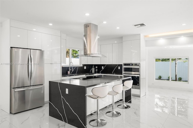 kitchen with a center island, white cabinets, stainless steel appliances, and extractor fan