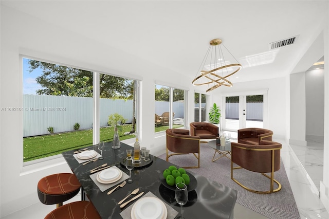 sunroom / solarium featuring an inviting chandelier