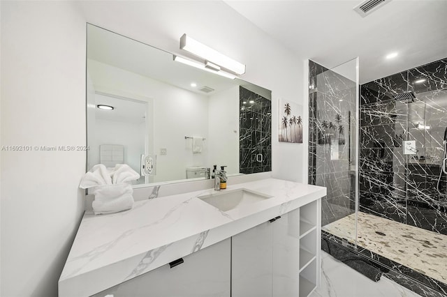 bathroom with a tile shower and vanity