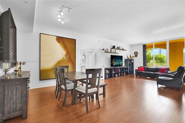 dining area with wood-type flooring and crown molding