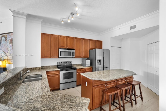 kitchen featuring sink, stainless steel appliances, kitchen peninsula, a textured ceiling, and a breakfast bar