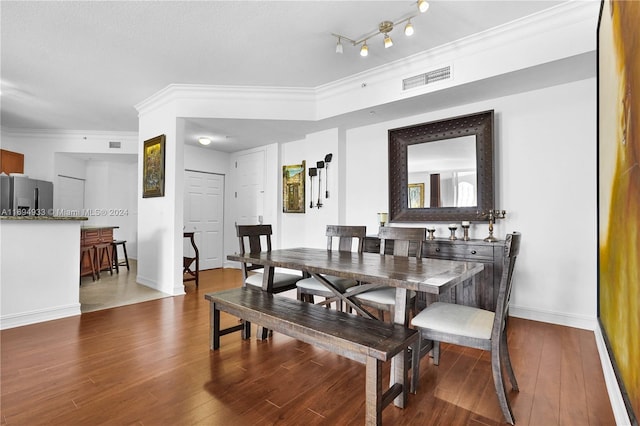 dining area with ornamental molding and hardwood / wood-style flooring