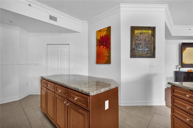 kitchen with light stone countertops, ornamental molding, and light tile patterned floors