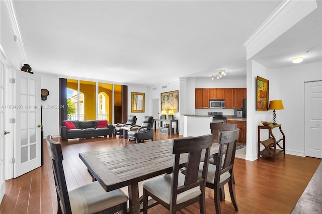 dining area featuring dark wood-type flooring and ornamental molding