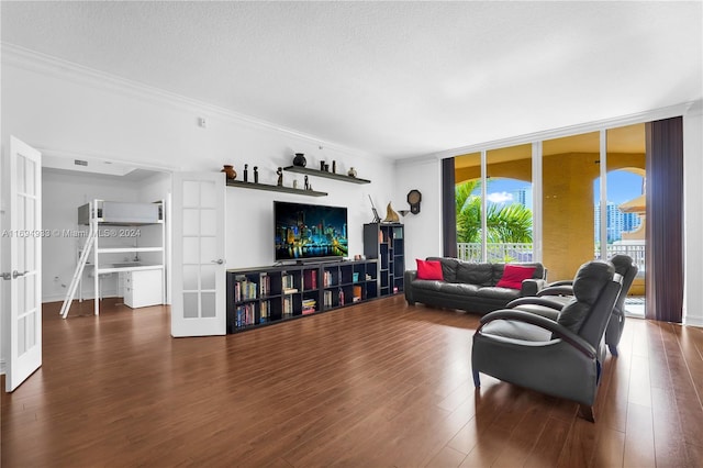 living room featuring french doors, a textured ceiling, crown molding, a wall of windows, and dark hardwood / wood-style floors