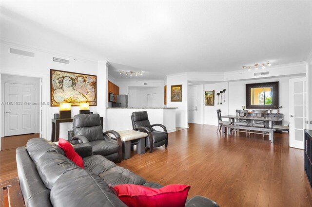 living room with dark hardwood / wood-style flooring and crown molding