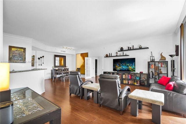 living room with wood-type flooring and ornamental molding