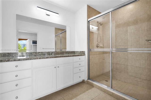 bathroom with tile patterned floors, vanity, and an enclosed shower