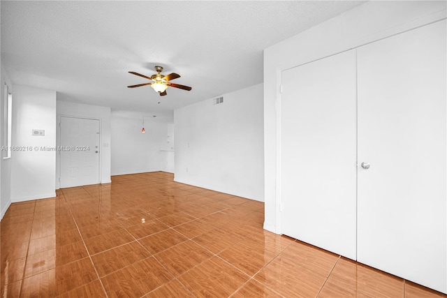 spare room with a textured ceiling and ceiling fan