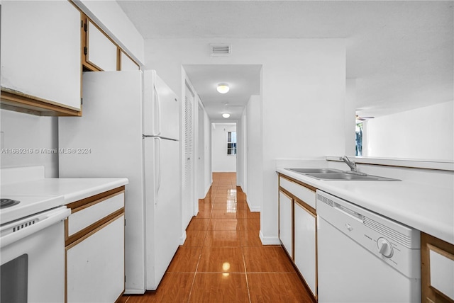 kitchen featuring white cabinetry, sink, light tile patterned floors, and white appliances