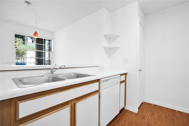 kitchen featuring white dishwasher, decorative light fixtures, white cabinetry, and sink