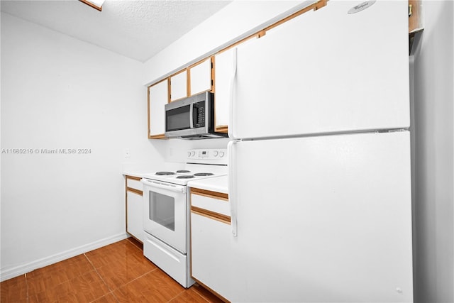 kitchen with white cabinets, a textured ceiling, white appliances, and light wood-type flooring