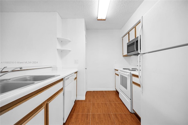 kitchen featuring white cabinetry, sink, white appliances, and a textured ceiling