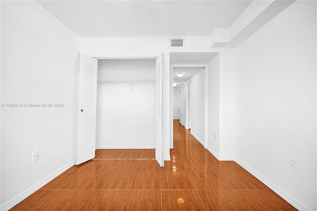 unfurnished bedroom with a textured ceiling and a closet