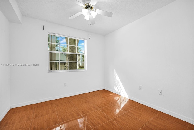 unfurnished room featuring ceiling fan and a textured ceiling