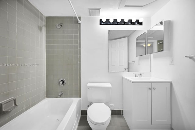 full bathroom featuring tile patterned floors, vanity, tiled shower / bath combo, and toilet