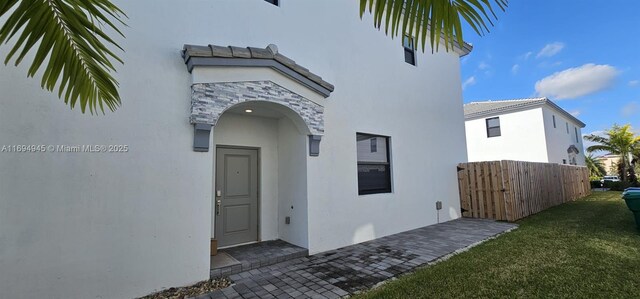 view of exterior entry with a lawn