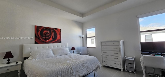 tiled bedroom with a raised ceiling