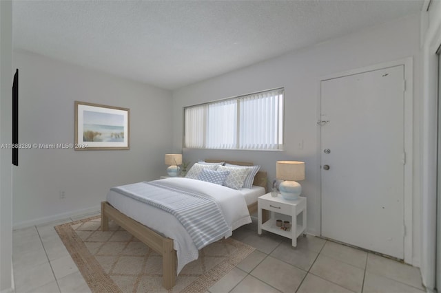 tiled bedroom featuring a textured ceiling