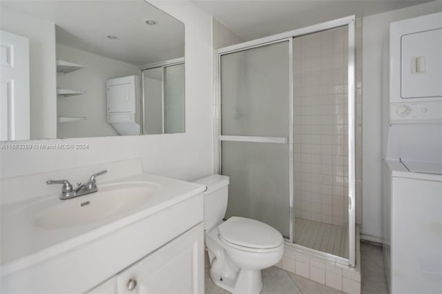 bathroom featuring tile patterned floors, stacked washer and dryer, vanity, and an enclosed shower