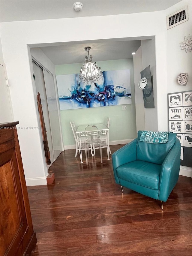 sitting room with dark hardwood / wood-style flooring and an inviting chandelier