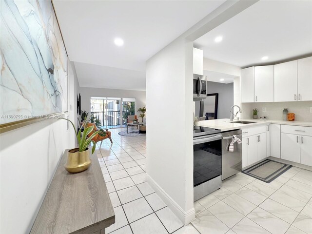 8415 SW 107th Ave Unit 356W, Miami, FL 33173 - kitchen with stainless steel appliances, a sink, light countertops, white cabinetry, and light tile patterned floors