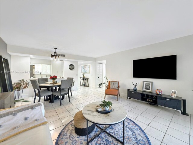 tiled living room with an inviting chandelier