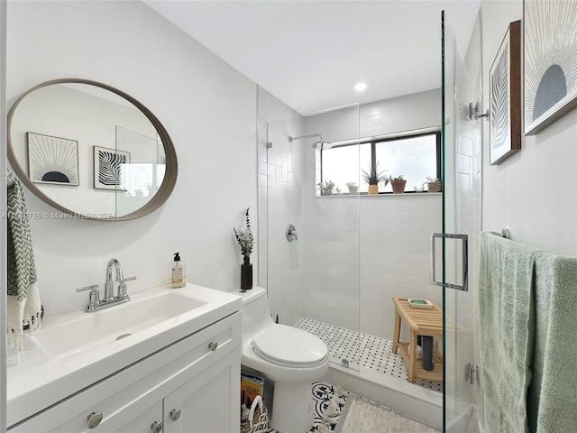 bathroom featuring a shower with door, vanity, and toilet