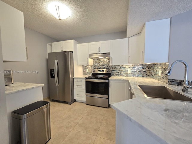 kitchen featuring backsplash, white cabinets, sink, a textured ceiling, and appliances with stainless steel finishes