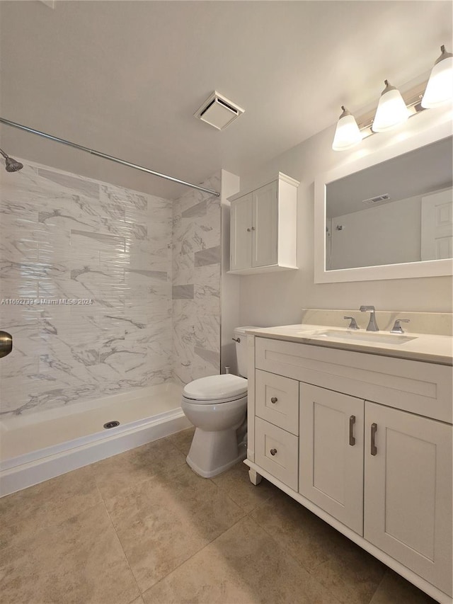 bathroom featuring tiled shower, vanity, and toilet