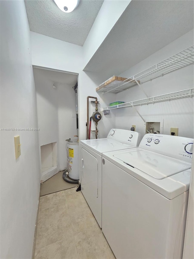 washroom featuring a textured ceiling and washing machine and clothes dryer