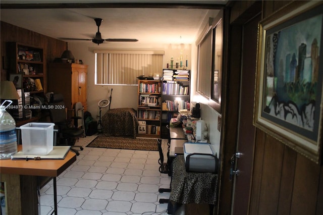 interior space with wood walls and ceiling fan