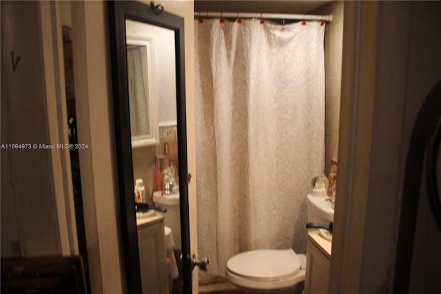 bathroom with a shower with curtain, vanity, and toilet